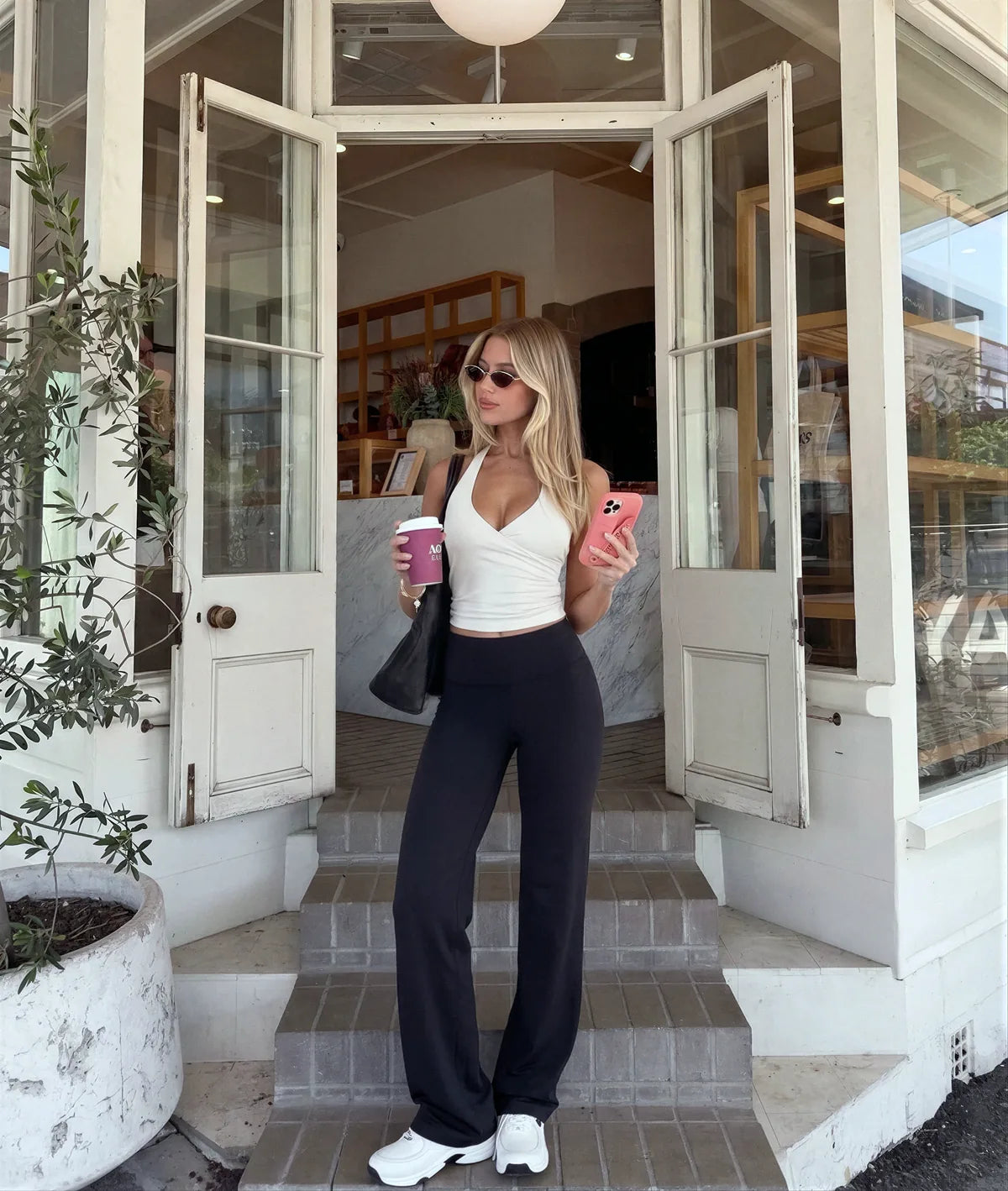 Woman wearing AirSculpt Wide-Leg Leggings in Black on a city street